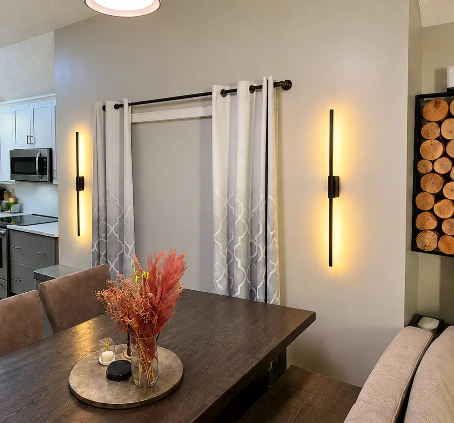 Dining room with two linear sconces and a pendant lit together